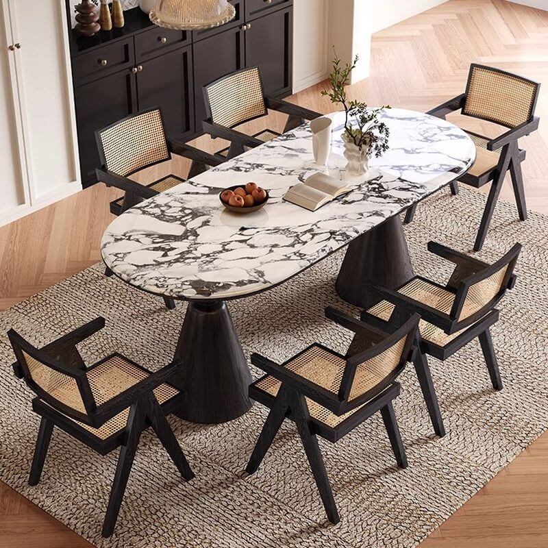 Oval marble dining table set with dual footing, solid back panel, and cushioned chairs