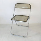 Contemporary acrylic folding armless chair with open back, ideal for dining rooms