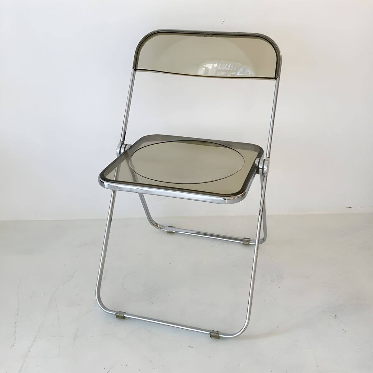 Contemporary acrylic folding armless chair with open back, ideal for dining rooms