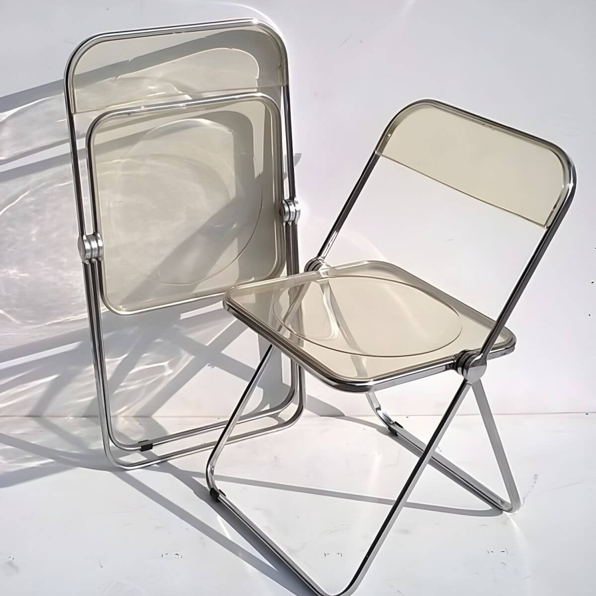 Contemporary acrylic folding armless chair with open back, ideal for dining rooms