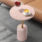 Pink terrazzo coffee table with gold accents in a modern minimalist design