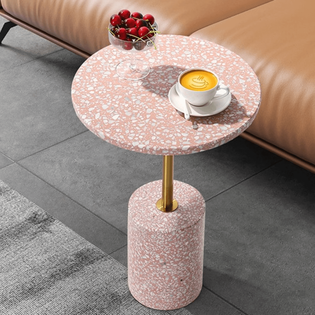 Pink terrazzo coffee table with gold accents in a modern minimalist design