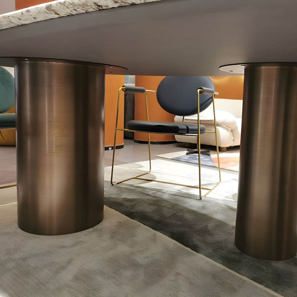 Oval marble dining table with white top and three gold steel legs