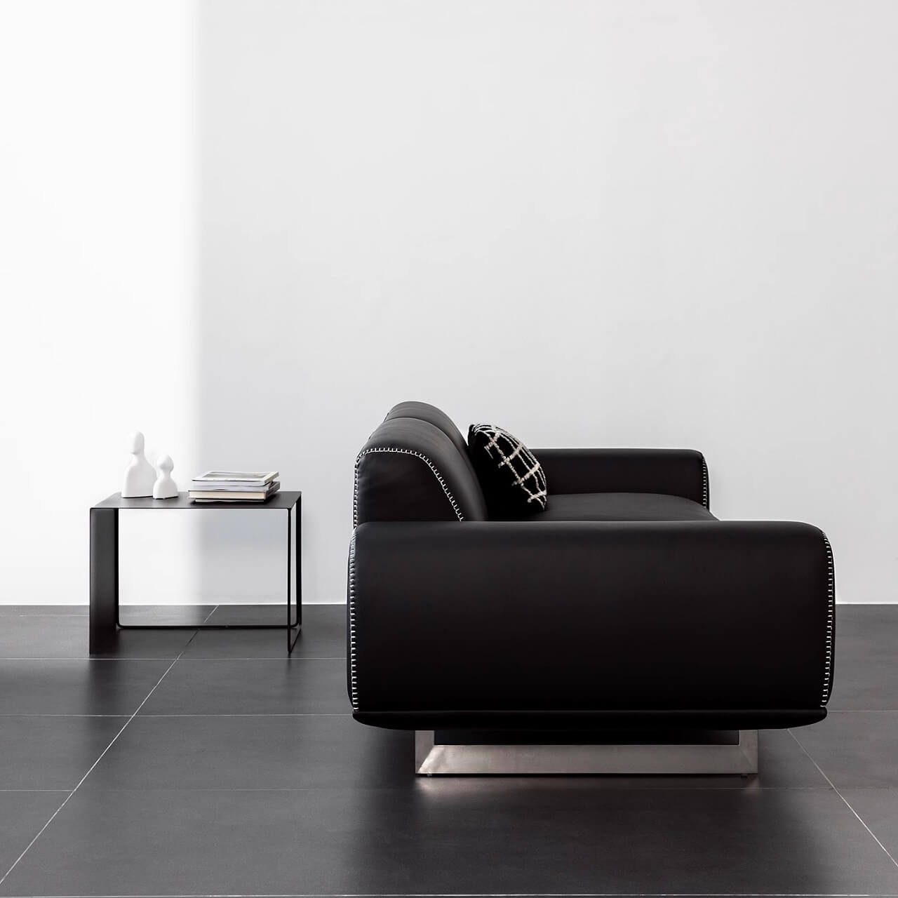 Contemporary minimalist black leather sofa comfortably seats three