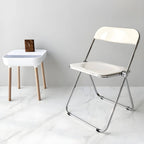 Contemporary acrylic folding armless chair with open back, ideal for dining rooms