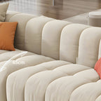 Beige upholstered wood sofa with square arms and sewn pillow back for modern living rooms