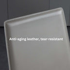 Single dining chair with gray saddle leather seat and carbon steel frame, minimalist luxury design