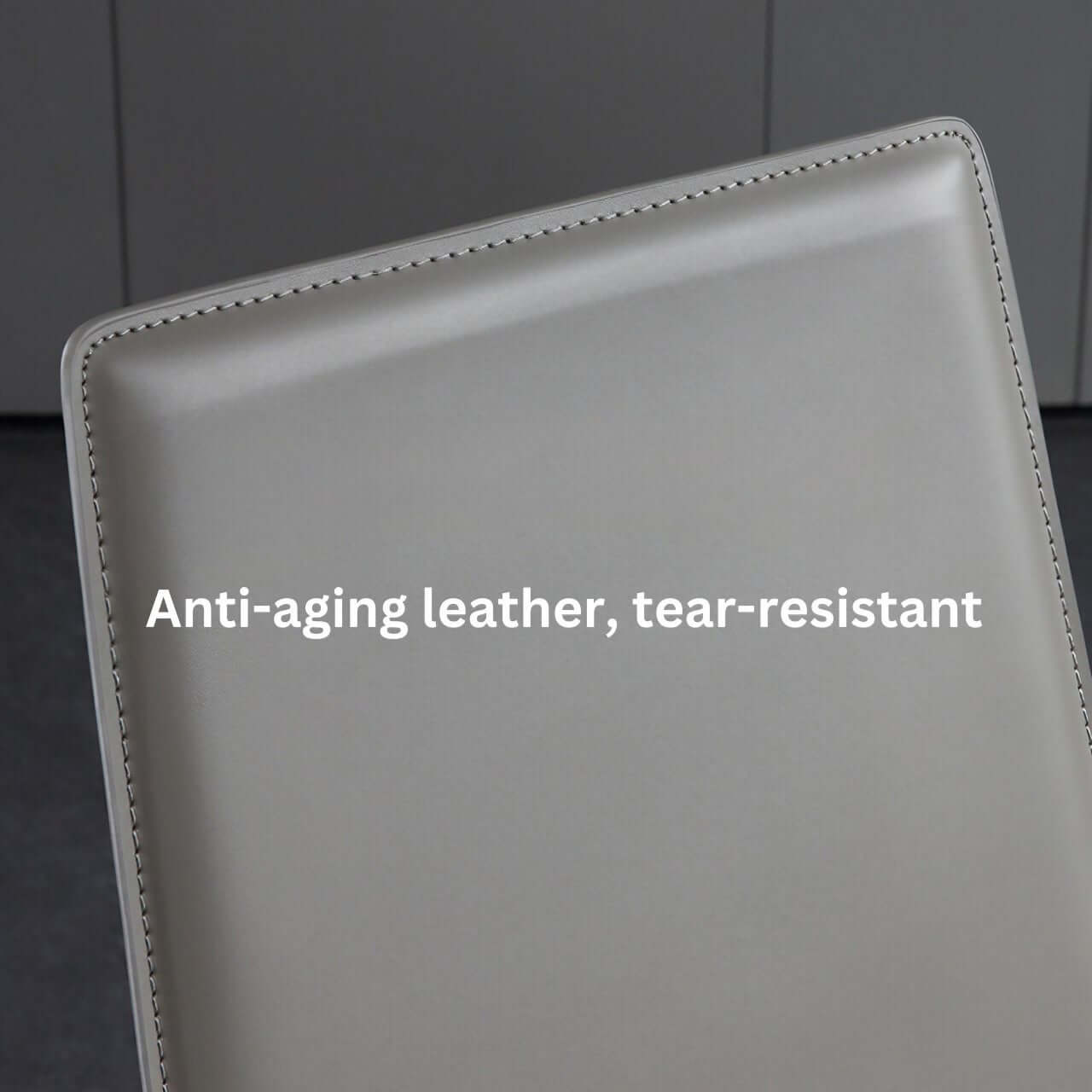 Single dining chair with gray saddle leather seat and carbon steel frame, minimalist luxury design