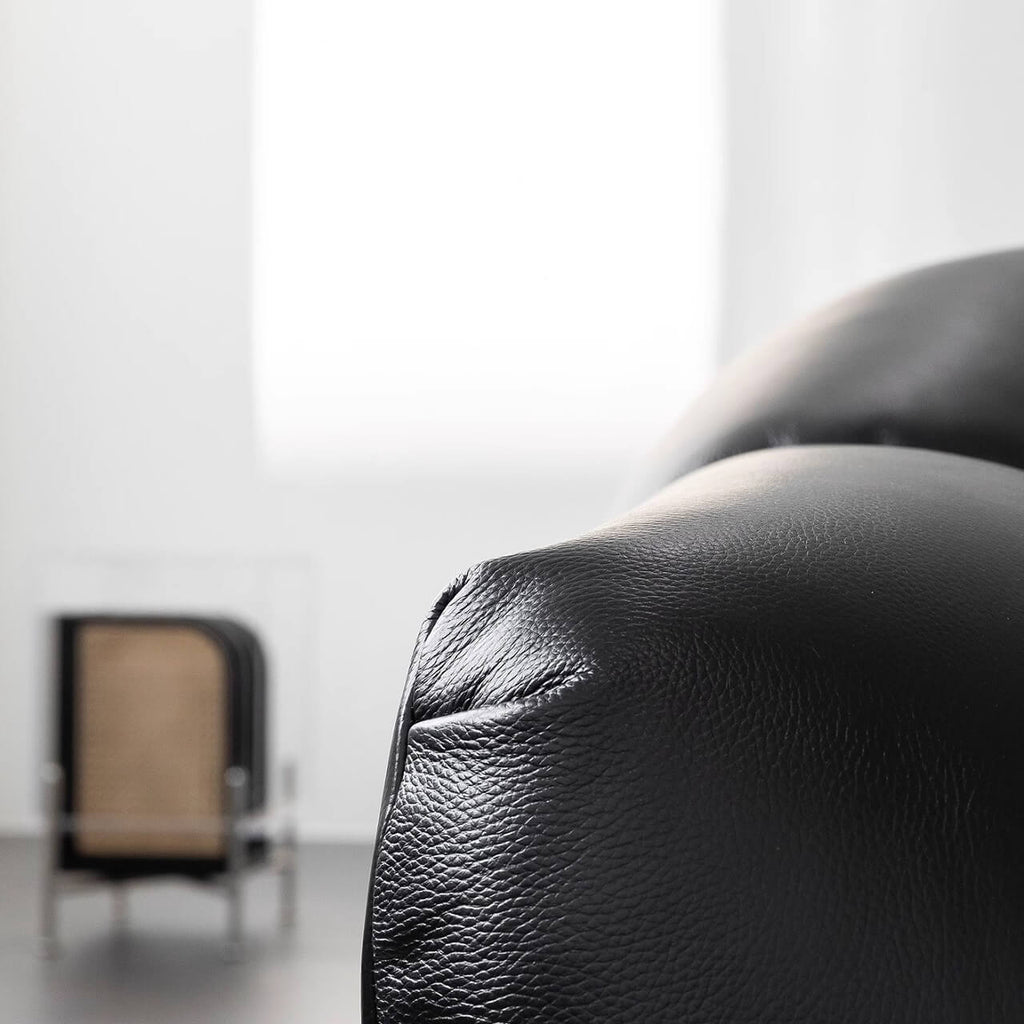 Black microfiber leather sofa with minimalist design, seats three comfortably