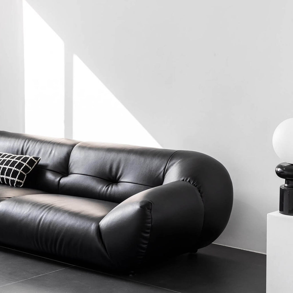 Black microfiber leather sofa with minimalist design, seats three comfortably