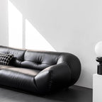 Black microfiber leather sofa with minimalist design, seats three comfortably