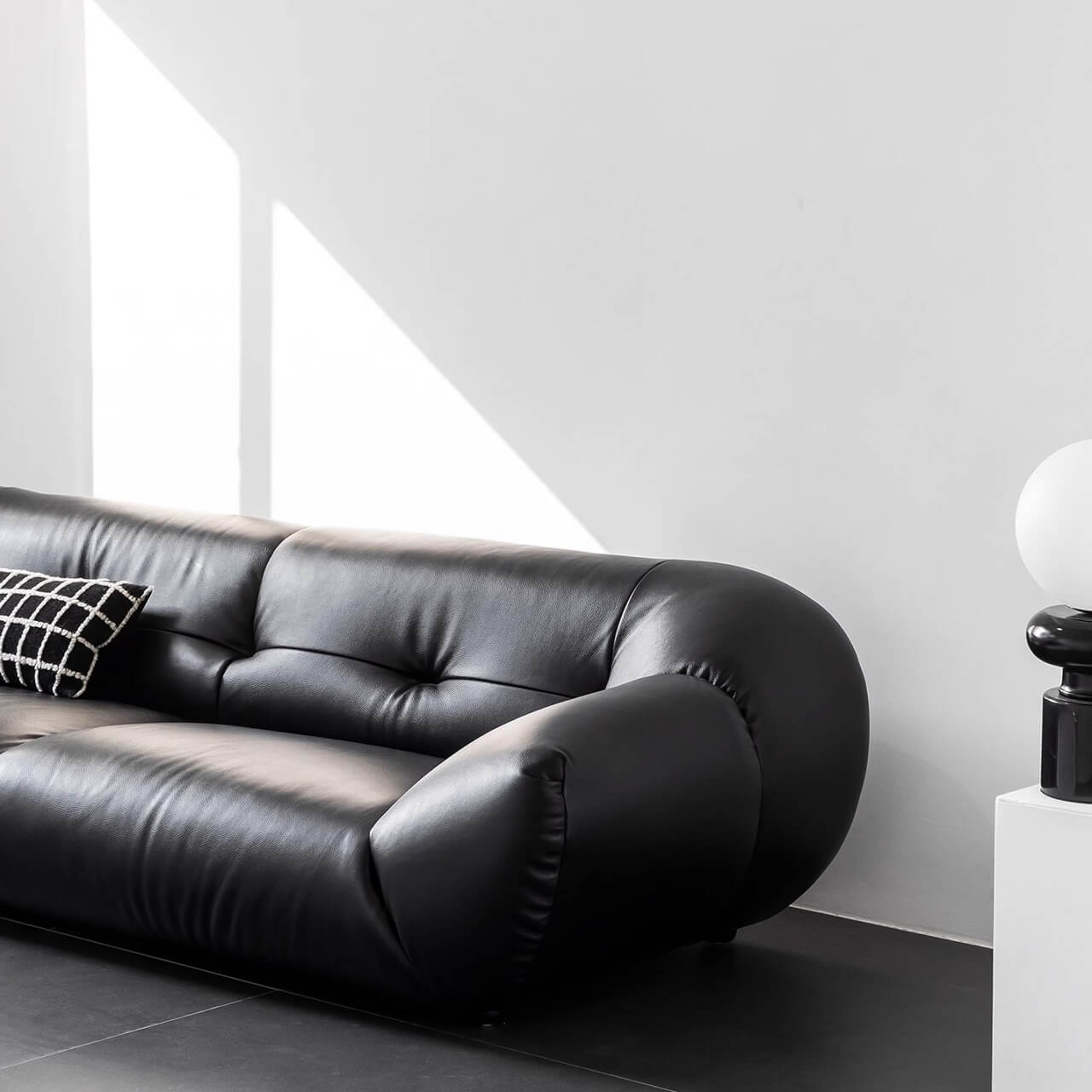 Black microfiber leather sofa with minimalist design, seats three comfortably