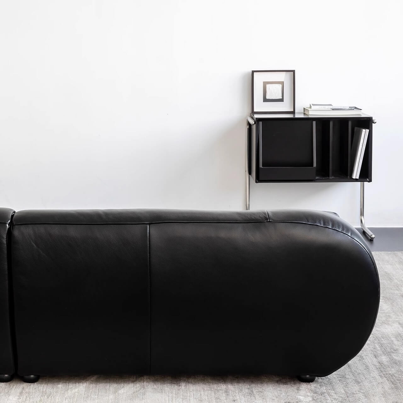 Black microfiber leather sofa with minimalist design, seats three comfortably