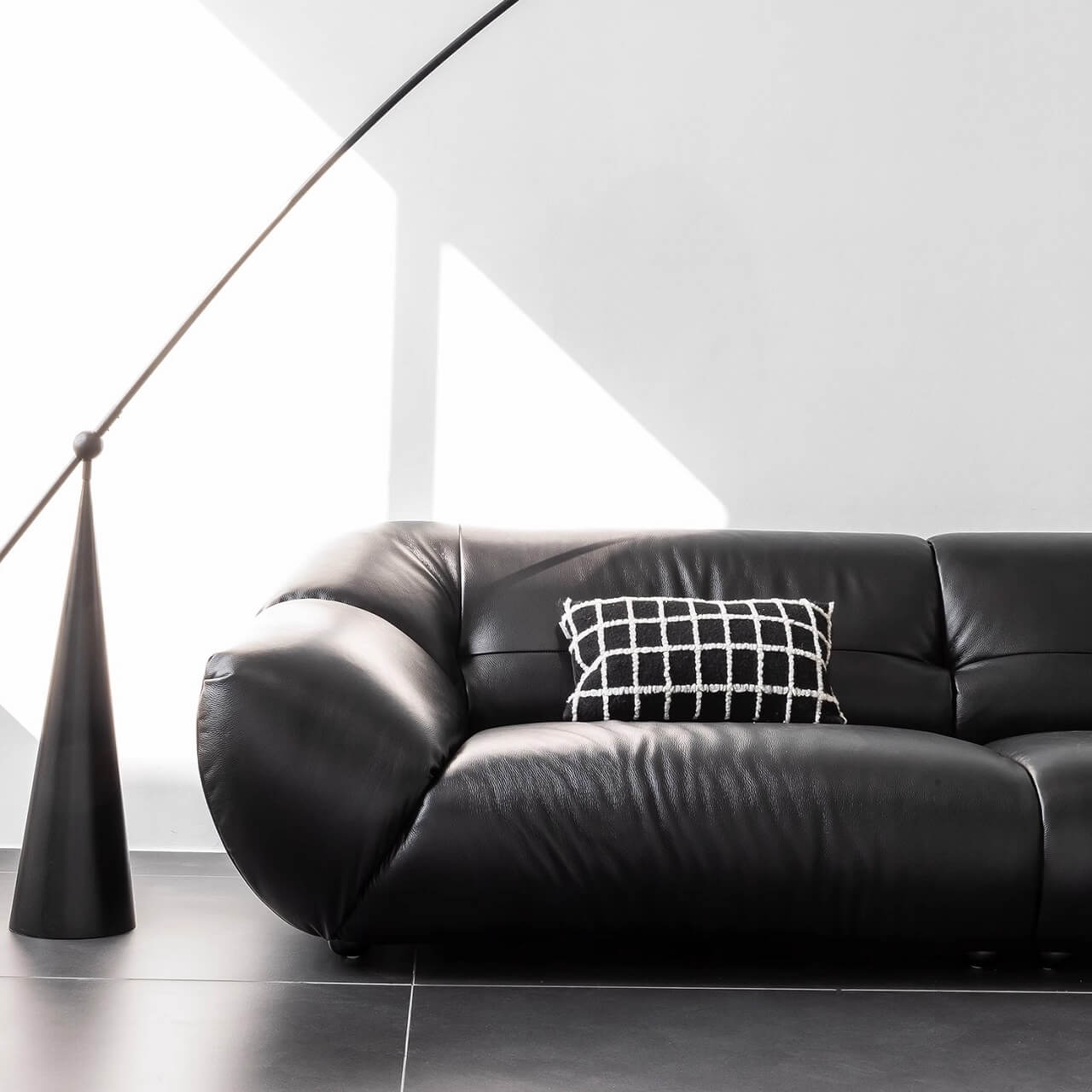 Black microfiber leather sofa with minimalist design, seats three comfortably