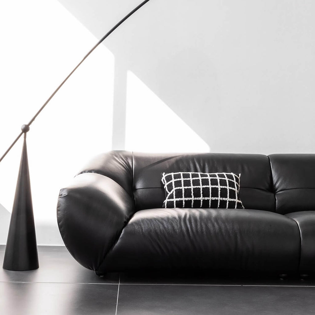 Black microfiber leather sofa with minimalist design, seats three comfortably