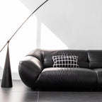 Black microfiber leather sofa with minimalist design, seats three comfortably