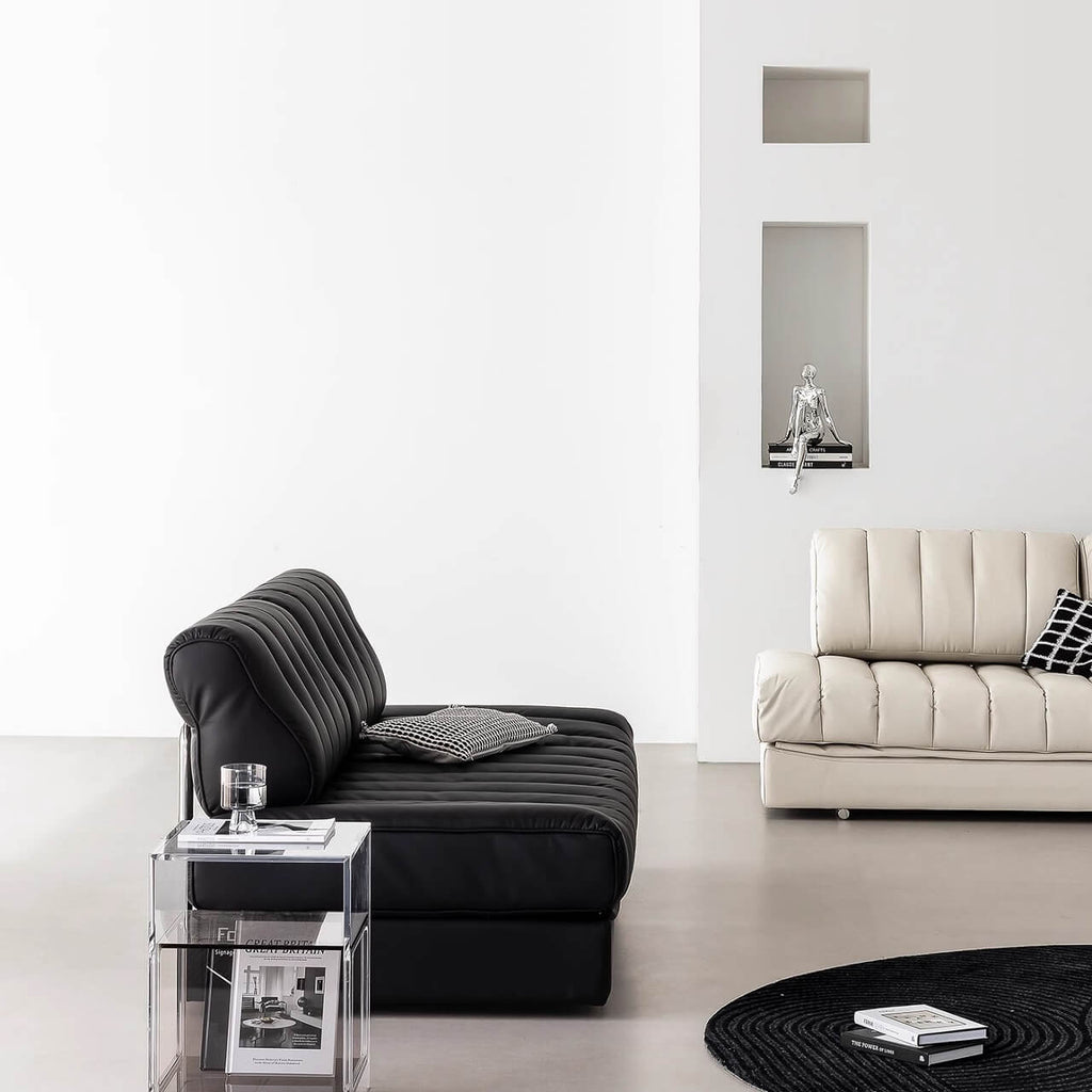 Black faux leather sofa bed with stainless steel frame and pillow arms for modern living rooms