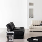 Black faux leather sofa bed with stainless steel frame and pillow arms for modern living rooms