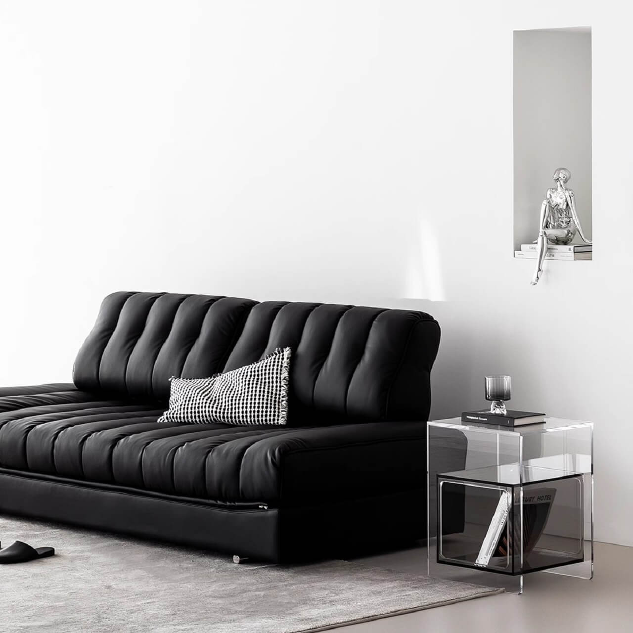 Black faux leather sofa bed with stainless steel frame and pillow arms for modern living rooms