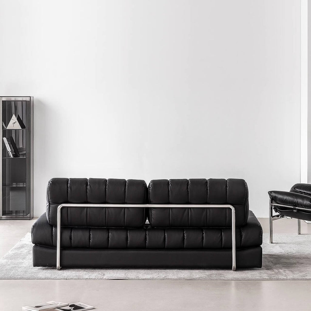 Black faux leather sofa bed with stainless steel frame and pillow arms for modern living rooms