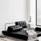 Black faux leather sofa bed with stainless steel frame and pillow arms for modern living rooms