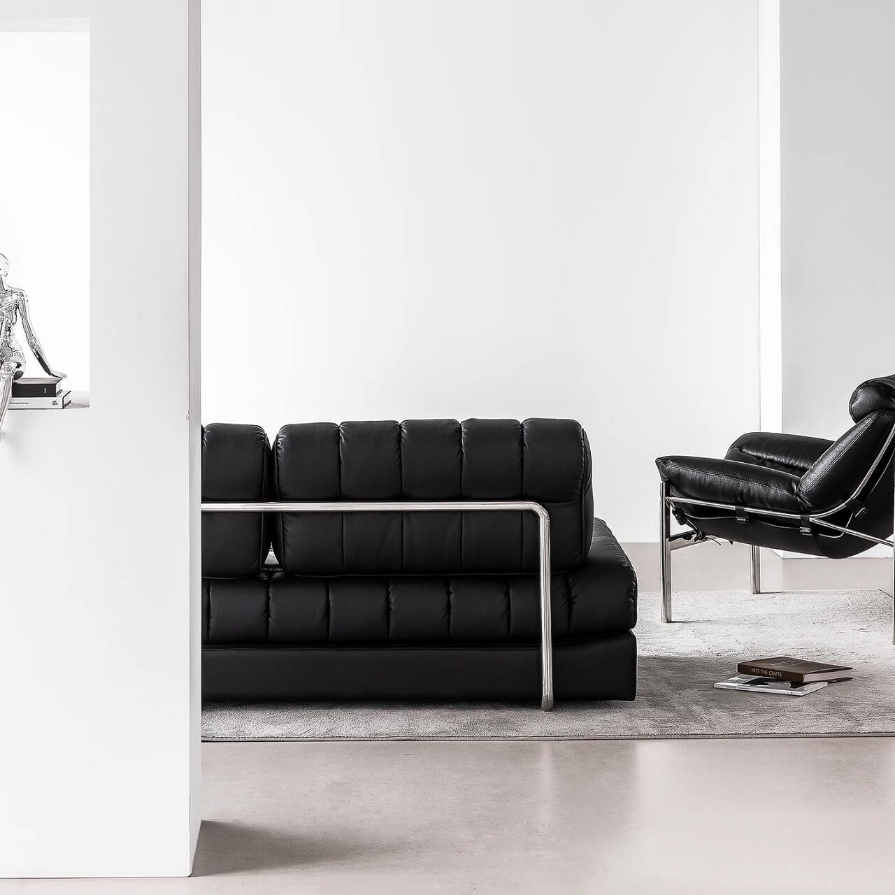 Black faux leather sofa bed with stainless steel frame and pillow arms for modern living rooms