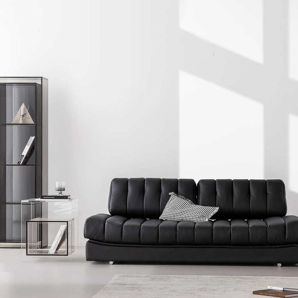 Black faux leather sofa bed with stainless steel frame and pillow arms for modern living rooms