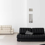 Black faux leather sofa bed with stainless steel frame and pillow arms for modern living rooms