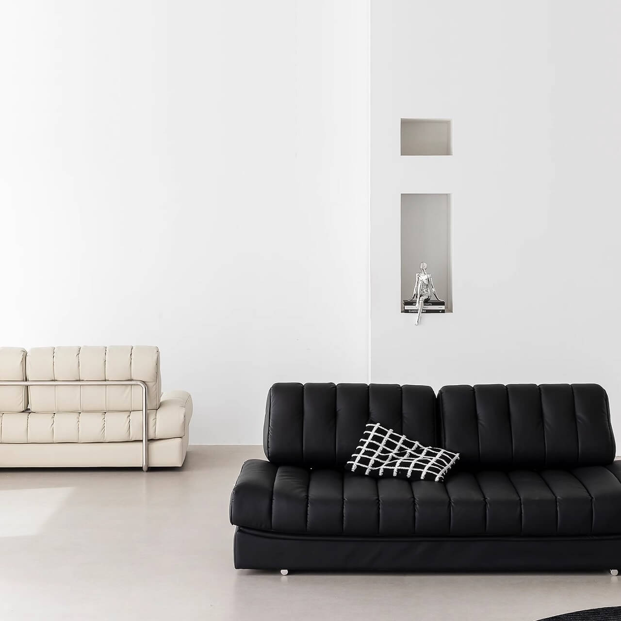 Black faux leather sofa bed with stainless steel frame and pillow arms for modern living rooms