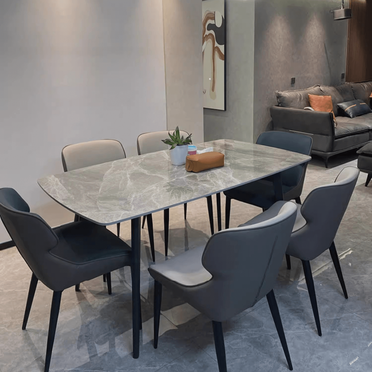 Modern grey dining table with bright rock surface and carbon steel legs in minimalist design