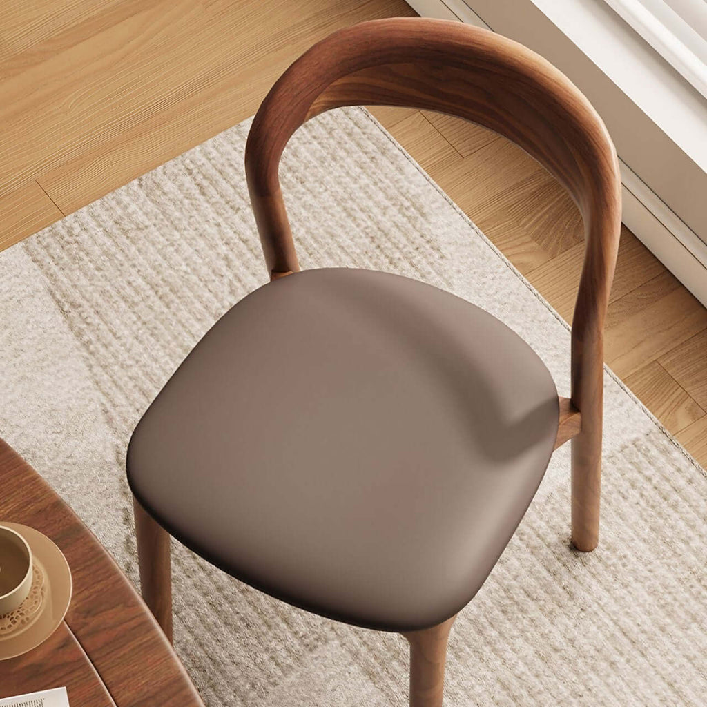 Brown leather dining chair with a modern curved back and simplistic design, single piece