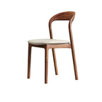 Brown leather dining chair with a modern curved back and simplistic design, single piece