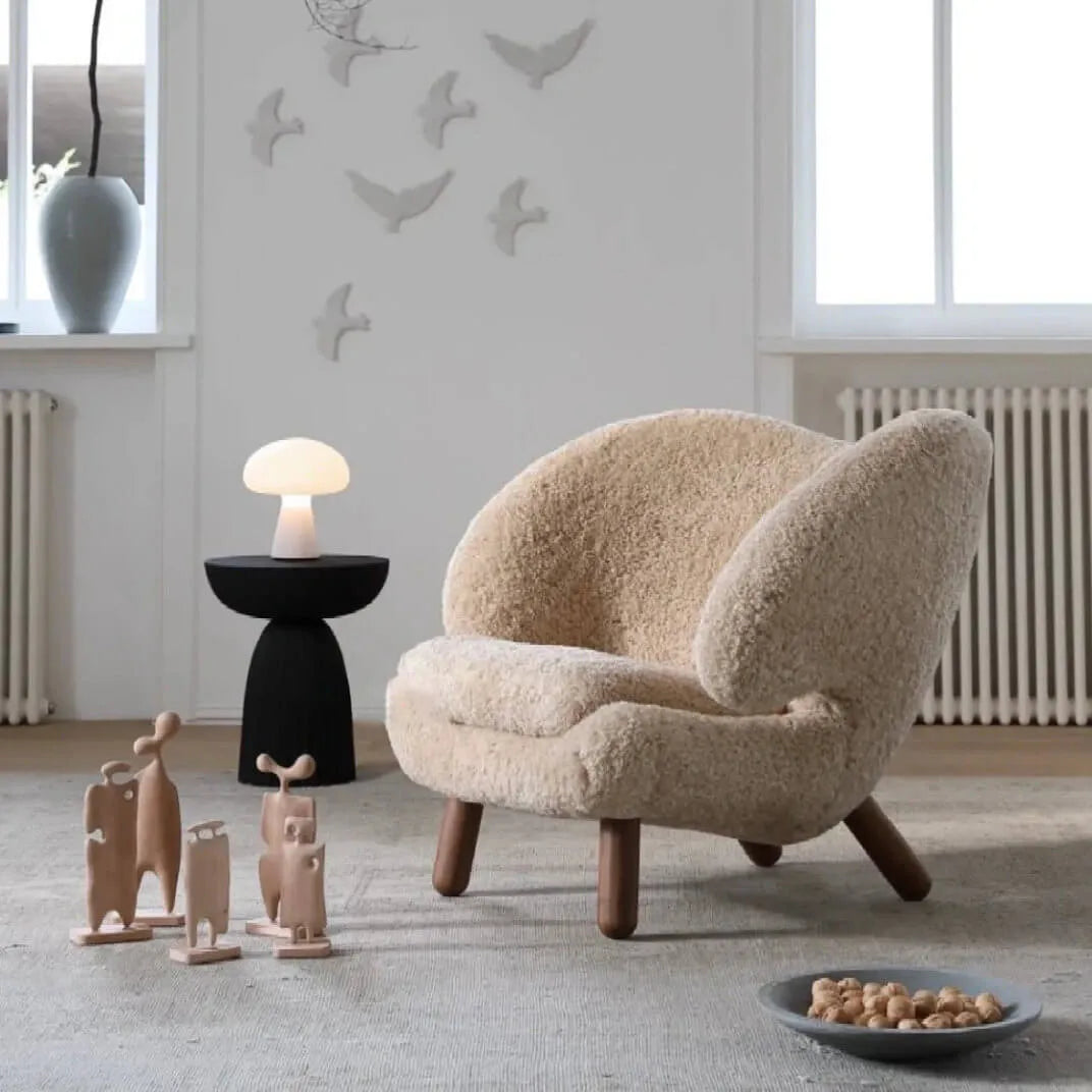 Shearling pelican chair with walnut legs and an ergonomic wingback silhouette