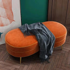 Modern orange velvet bench with gold legs in a contemporary design