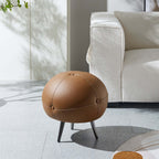 Modern round brown ottoman with buttoned faux leather upholstery for contemporary home decor