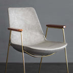 Modern upholstered dining chair in black PU leather with stylish gold metal legs