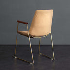 Contemporary black dining chair with gold legs and comfortable faux leather seat