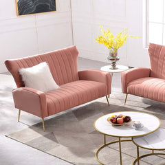 Pink velvet upholstered sofa with channel tufted design and wingback chair style