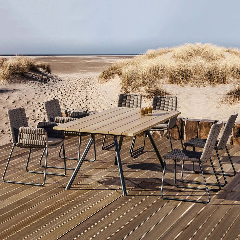 Outdoor dining set featuring 7 pieces of aluminum furniture with a beautiful teak wood top table and attractive rope chairs