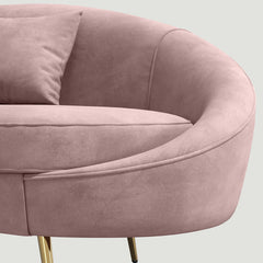 Modern 63 inch pink velvet sofa with curved design, gold metal frame, and matching toss pillow