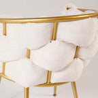 Sophisticated beige upholstered armchair with shimmering gold legs for luxury interiors