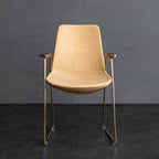 Sophisticated upholstered dining chair with gold legs in black faux leather material