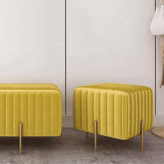 Chic square footrest upholstered in luxurious yellow velvet