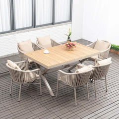 7-piece outdoor dining set with wood-top table and woven rattan armchair in natural setting