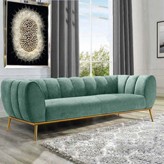 Luxurious emerald green velvet couch with elegant gold stainless steel base