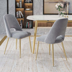 Sleek modern upholstered dining chairs in black with hollow back and shiny gold legs