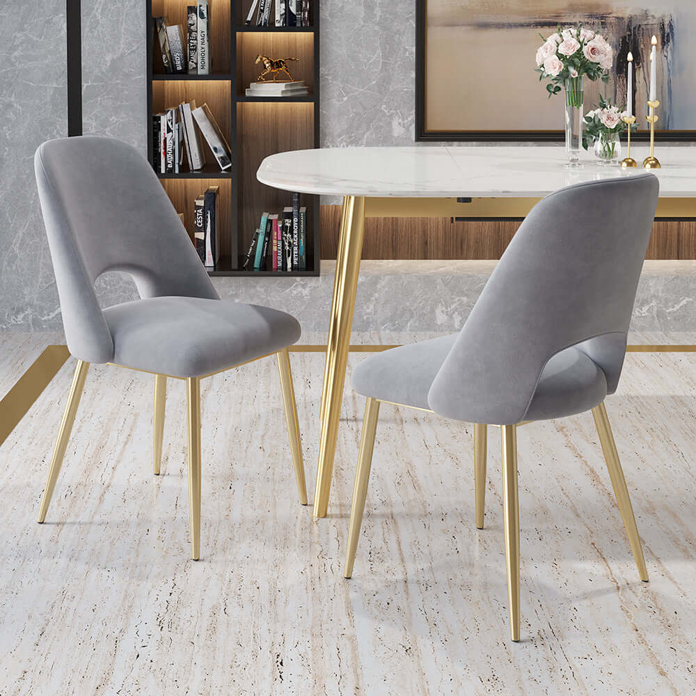 Sleek modern upholstered dining chairs in black with hollow back and shiny gold legs