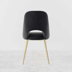 Trendy modern dining chairs in black upholstery with hollow back and elegant gold legs