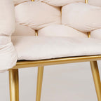 Trendy beige upholstered armchair with elegant gold legs for contemporary interiors