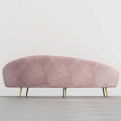 Modern 63 inch pink velvet sofa with curved design, gold metal frame, and matching toss pillow